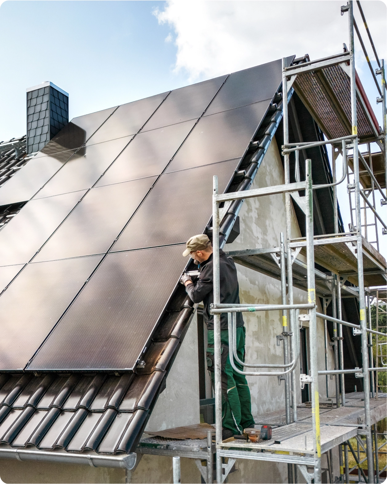 Expert qui est en train d'installer quatorze panneaux solaires photovoltaïques sur le toit d'une maison