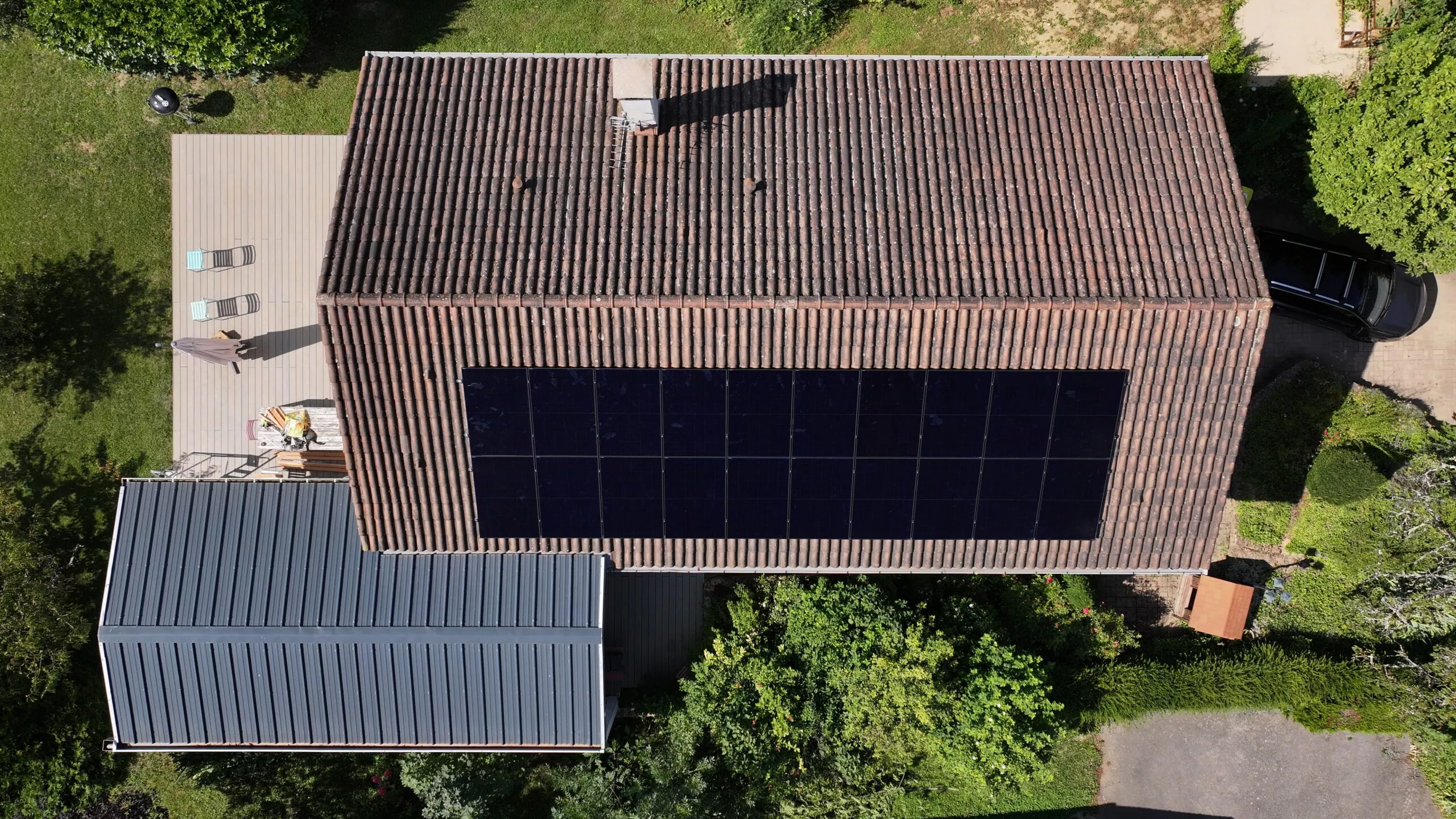 Vue de haut d'une jolie maison avec des panneaux solaires photovoltaïques en autoconsommation avec vente de surplus à Saint Cyr au Mont d'Or