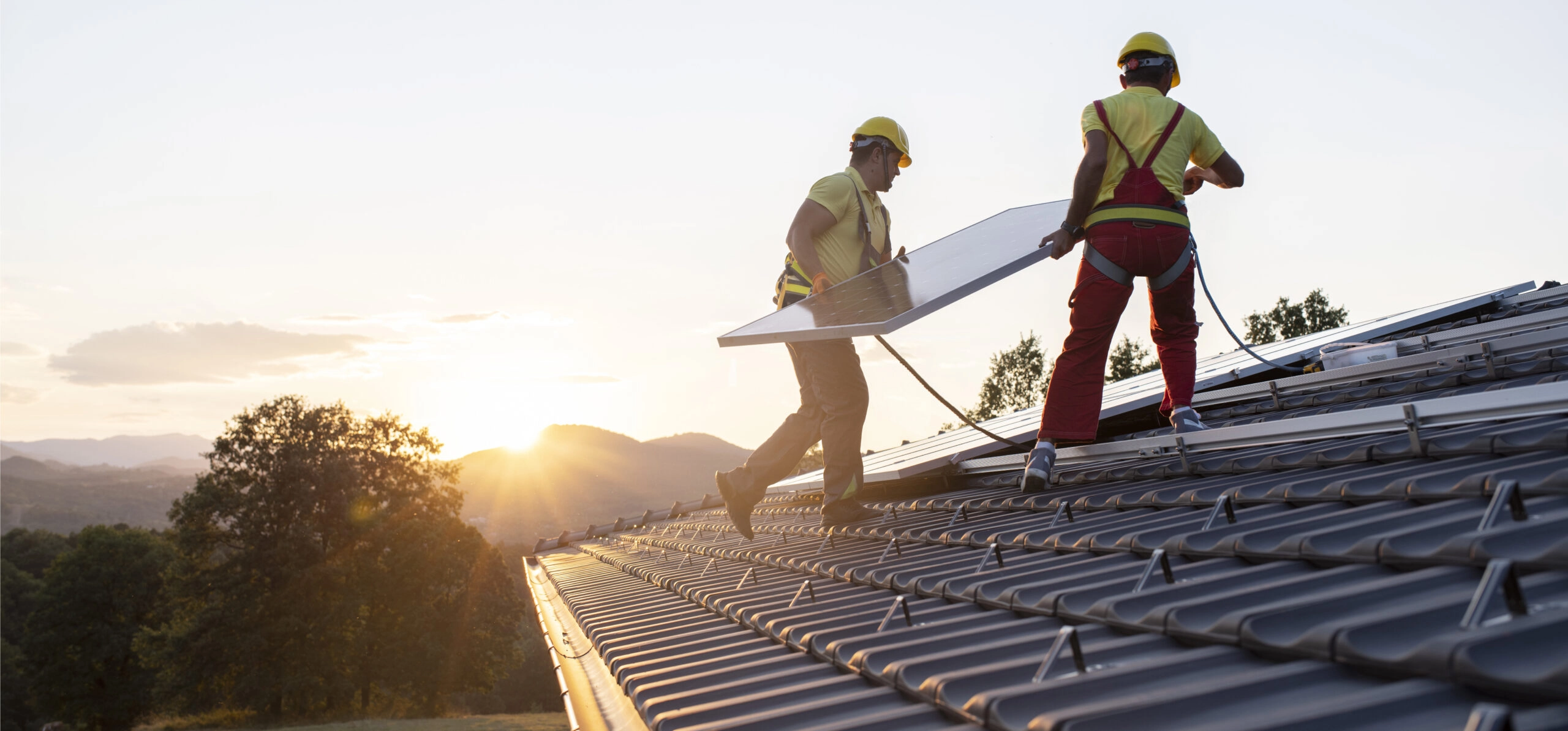 Vue de techniciens installant des panneaux solaires photovoltaïques en autoconsommation sur un toit de maison