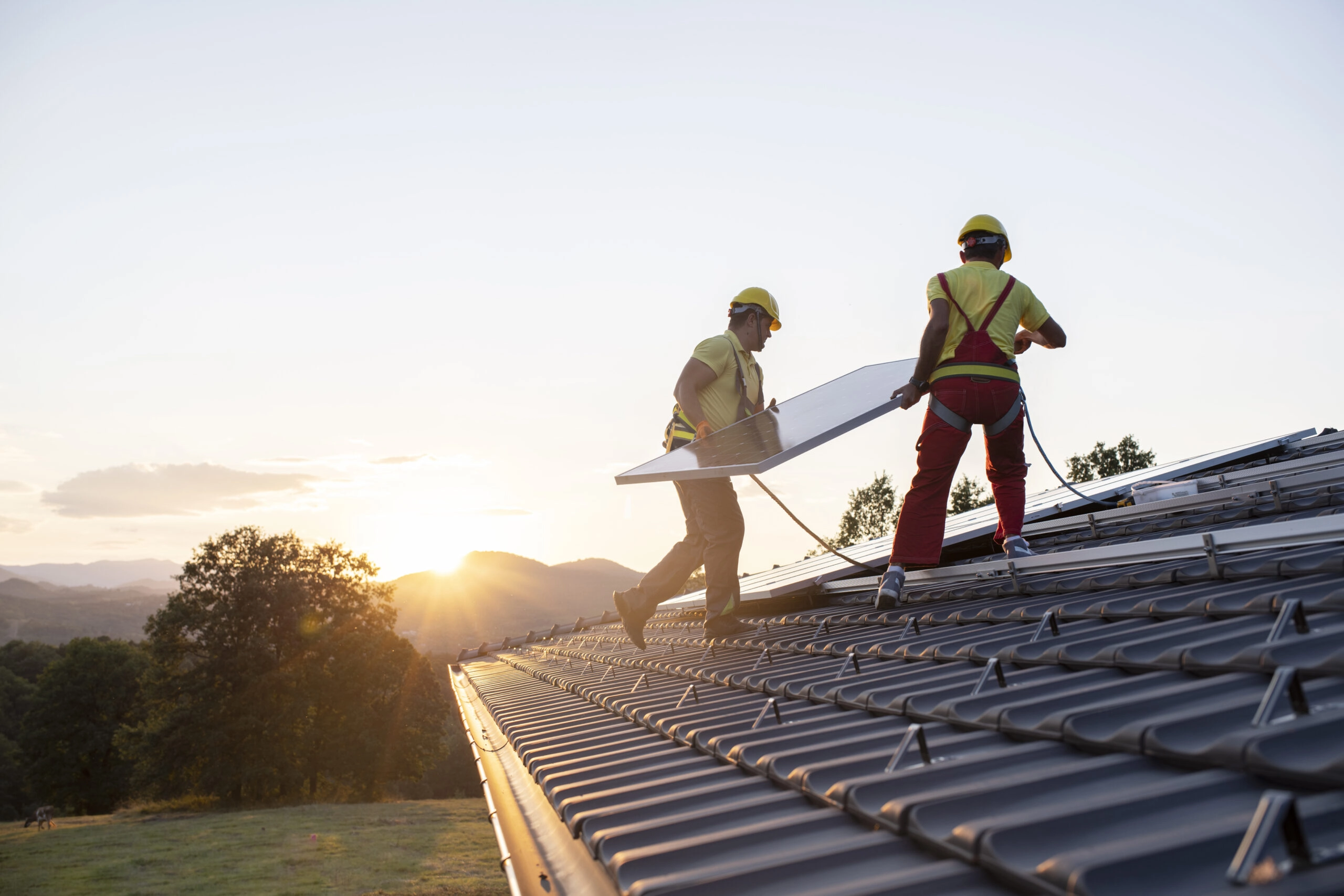 Vue de techniciens installant des panneaux solaires photovoltaïques en autoconsommation sur un toit de maison