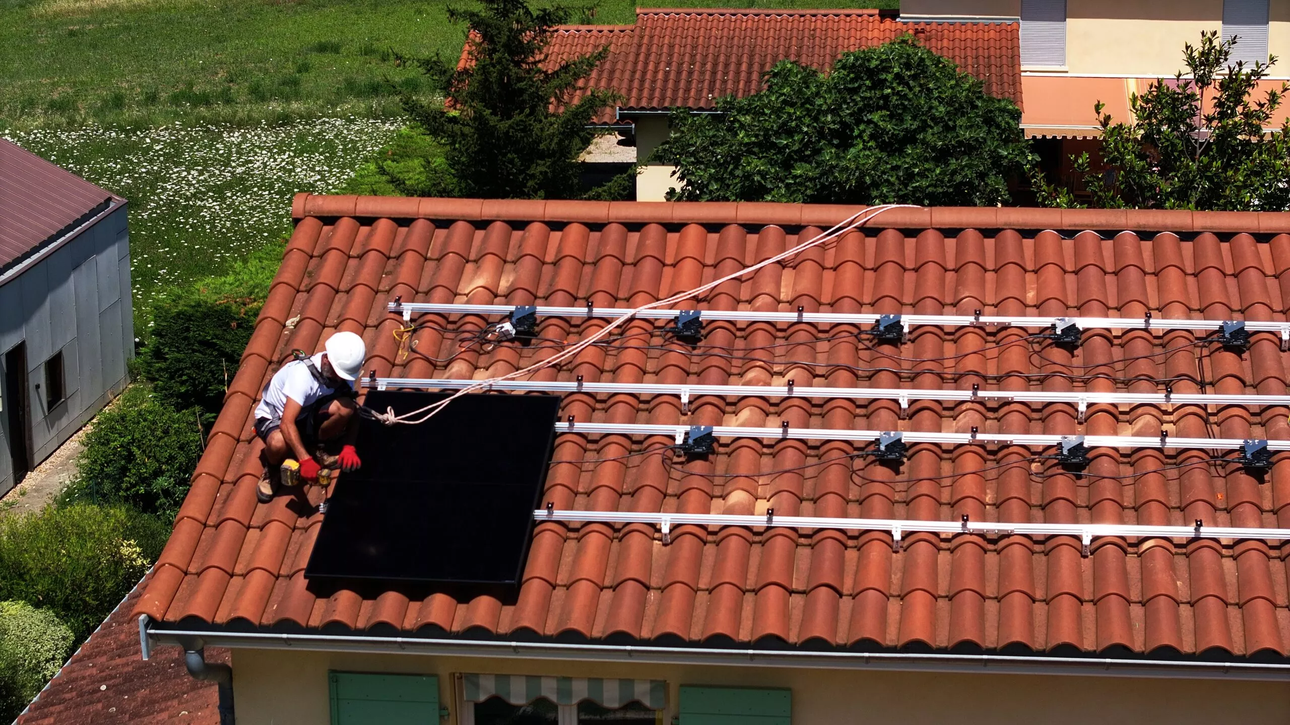 Technicien en train d'installer l'un des panneaux solaires photovoltaïques pour une solution en autoconsommation avec vente de surplus à Curis au Mont d'Or